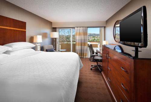 ein Hotelzimmer mit einem Bett und einem Flachbild-TV in der Unterkunft Sheraton Agoura Hills Hotel in Agoura Hills