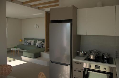a kitchen with a refrigerator and a living room at Les Maisonettes in Kokkari