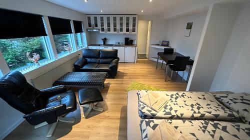 sala de estar con sofá y sillas y cocina en Ingi's Guesthouse with a Car, en Miðvágur