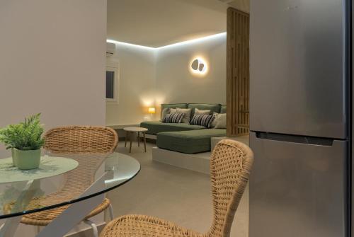 a living room with a couch and a table and chairs at Les Maisonettes in Kokkari