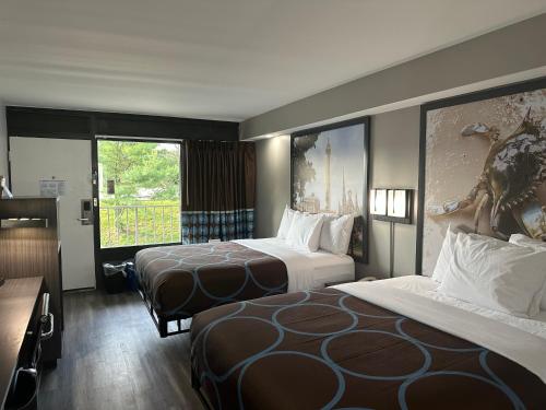 um quarto de hotel com duas camas e uma janela em Super 8 by Wyndham Baltimore Northwest em Baltimore
