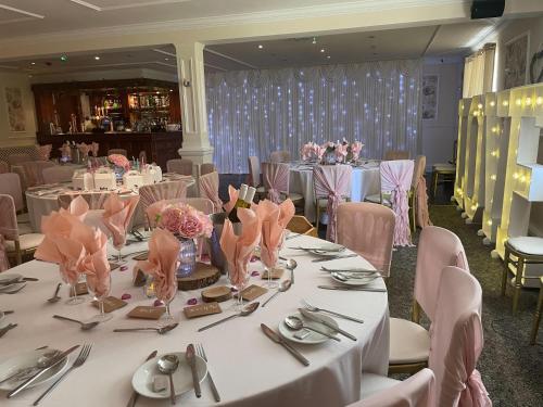 Goxhill的住宿－The Gardeners Country Inn，用餐室配有桌椅和粉红色的鲜花