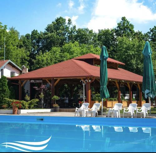 - une piscine avec des chaises et des parasols à côté d'un bâtiment dans l'établissement Kosmajski Izvor, à Sopot