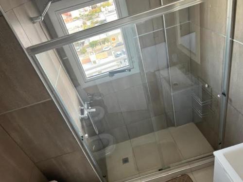 W łazience znajduje się przeszklony prysznic z oknem. w obiekcie Moderno depto con vista panorámica w mieście Comodoro Rivadavia