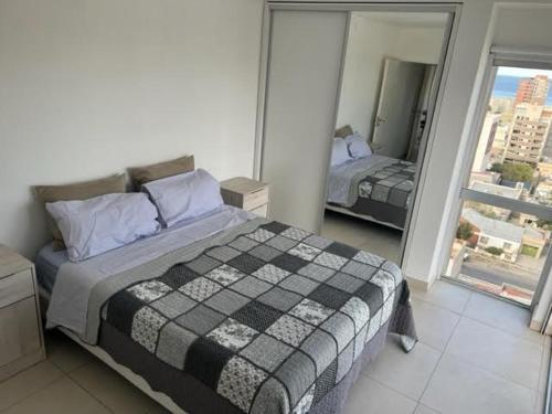 sypialnia z łóżkiem i dużym oknem w obiekcie Moderno depto con vista panorámica w mieście Comodoro Rivadavia