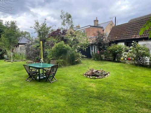 a table and chairs sitting in a yard at Quirky 18th Century Thatched Cottage in Great Staughton