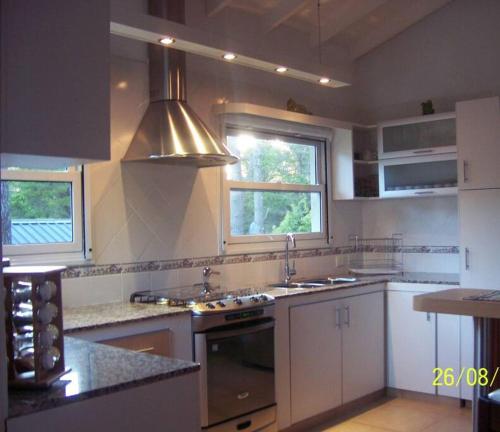 a kitchen with a sink and a stove top oven at Casa en Pinamar Alquiler in Pinamar