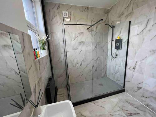 um chuveiro com uma porta de vidro na casa de banho em Sleek & Stylish Spacious Apartment near Leeds City Centre em Headingley