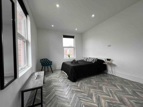 a white room with a bed and a window at Sleek & Stylish Spacious Apartment near Leeds City Centre in Headingley