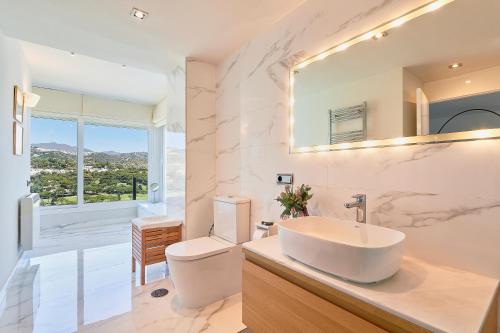 a bathroom with a sink and a toilet and a mirror at Torre Real Vistas 360 cerca Trocadero Arena Marbella in Marbella