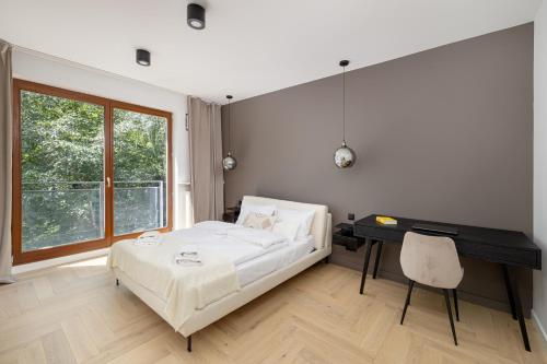Schlafzimmer mit einem Bett und einem Schreibtisch in der Unterkunft ECRU 3-Bedroom Luxurious Apartment with City View WWA22 in Warschau
