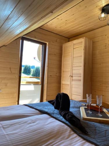 a bedroom with a bed with two glasses on a tray at Apartamenty Migaczówka in Tylicz