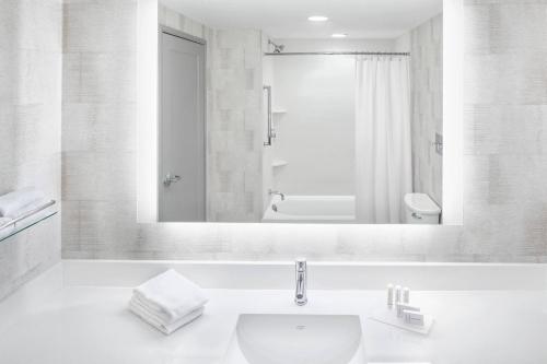 Baño blanco con lavabo y espejo en Residence Inn by Marriott Big Sky/The Wilson Hotel en Big Sky