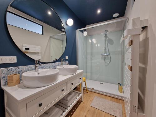 uma casa de banho com 2 lavatórios e um espelho grande em Le Nid du Chardonnay 