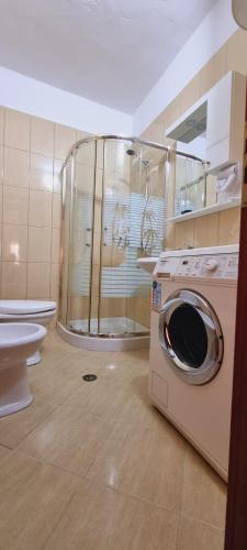 Un baño con lavadora y un inodoro. en Liam's Apartment, en Golem