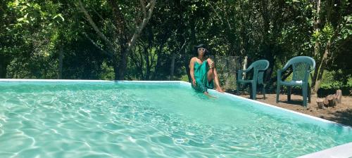 a woman is standing in a swimming pool at Quinta dos Castros Douro in Baião