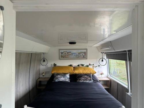 a bed in the back of a tiny house at Mooview- the charming double decker bus in Norton