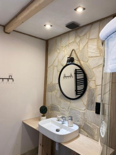 a bathroom with a sink and a mirror on the wall at Apartamenty Migaczówka in Tylicz