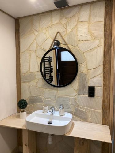 a bathroom with a sink and a mirror at Apartamenty Migaczówka in Tylicz