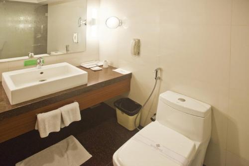 a bathroom with a white toilet and a sink at Hotel Silver Palace in Rajkot