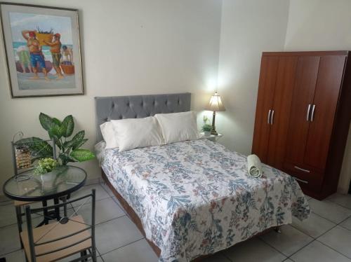 een slaapkamer met een bed, een kast en een tafel bij Private Guest House in Lima