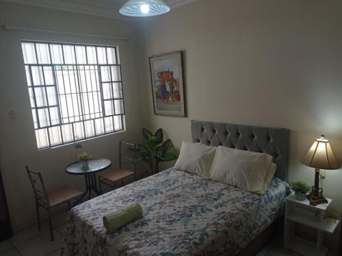 una camera con un letto e un tavolo e due finestre di Private Guest House a Lima