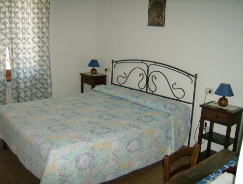 アッシジにあるB&B Il Sentiero di Assisiのベッドルーム1室(ベッド1台、ランプ付きテーブル2台付)