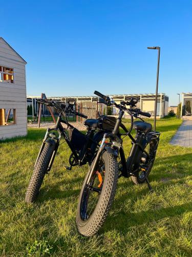 a motorcycle parked in the grass next to a house at Resto domki letniskowe in Sarbinowo