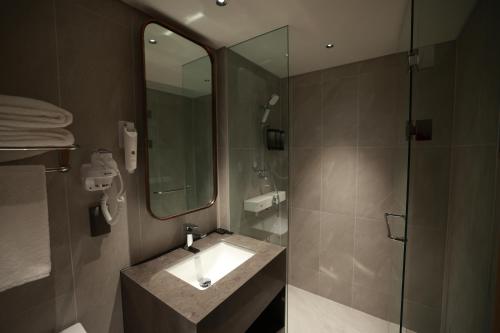 a bathroom with a sink and a shower with a mirror at Incheon Airport Transit Hotel Terminal 1 in Incheon
