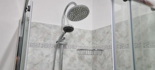 een douche met een douchekop in de badkamer bij YUDI HOUSE in Aosta