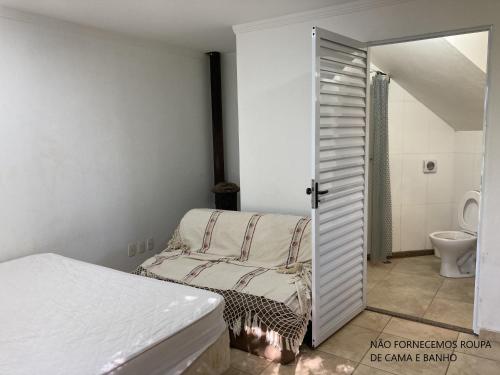 um quarto com uma cama e uma casa de banho com um WC em Recanto Alpinista natureza e aventura para família e casais de amigos em Monte Verde