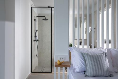 a shower with a glass door in a bedroom at Beachfront Salty Sea Luxury Suite 1 in Agios Nikolaos