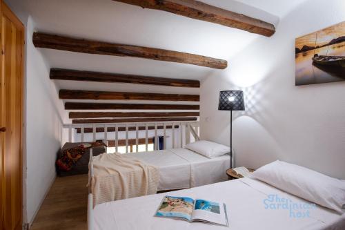 a bedroom with two beds and a ceiling with beams at Porto Rotondo loft sul porto in Porto Rotondo