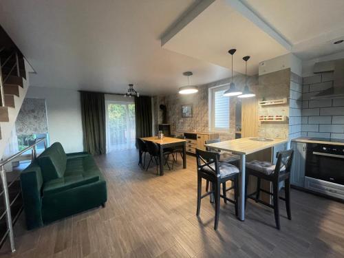 eine Küche und ein Wohnzimmer mit einem Tisch und Stühlen in der Unterkunft Rooms4Rent Cottage in Klaipėda