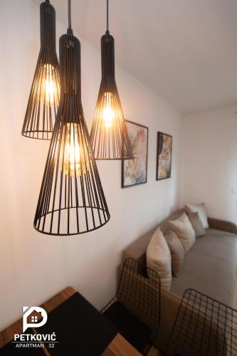 a bedroom with three lights hanging from the ceiling at Petković apartmani STUDIO32 in Jagodina