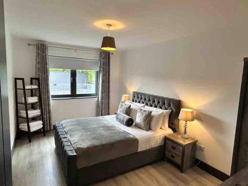 a bedroom with a large bed and a window at Killarney modern family cottage in Killarney