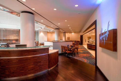 a restaurant with a bar and a dining room at Tulsa Marriott Southern Hills in Tulsa