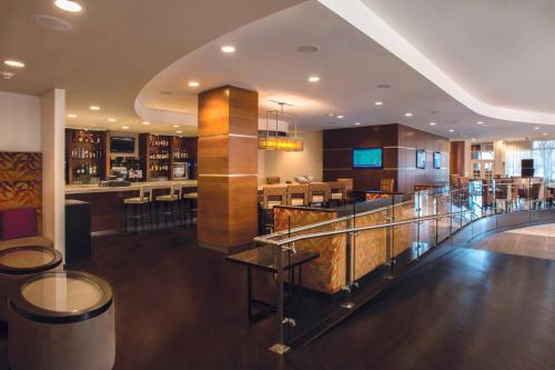 a lobby of a hotel with a bar and a restaurant at Tulsa Marriott Southern Hills in Tulsa