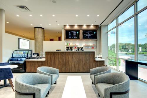 a lobby with chairs and a bar with a view at Tulsa Marriott Southern Hills in Tulsa