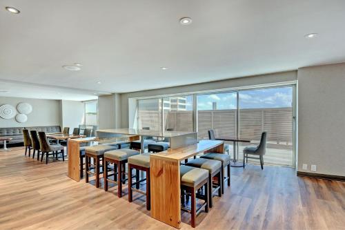 a restaurant with tables and chairs and a large window at Tulsa Marriott Southern Hills in Tulsa