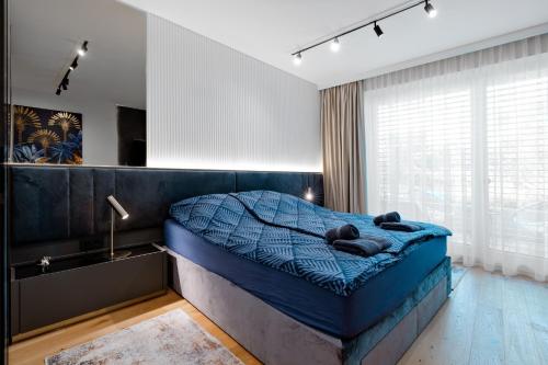 ein Schlafzimmer mit einem blauen Bett in einem Zimmer mit einem Fenster in der Unterkunft Sunhill Residence 5* suite Castle district in Budapest