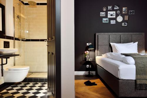 a bathroom with a bed and a shower and a toilet at Syte Boutique Hotel Mannheim in Mannheim