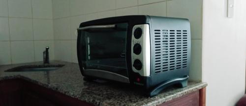 a microwave sitting on a counter next to a sink at Morita INN in San Salvador de Jujuy