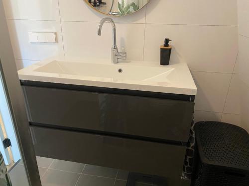 a bathroom with a white sink and a mirror at Beachhouse Wijk aan Zee 6 guests near beach free parking in Wijk aan Zee
