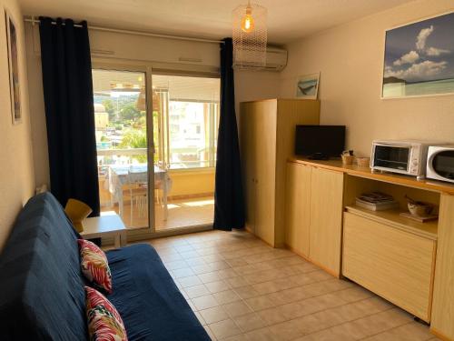 a living room with a couch and a microwave at Appartement La Favière in Bormes-les-Mimosas