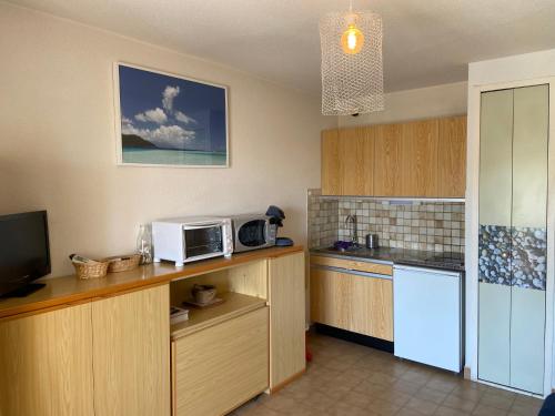 a kitchen with a microwave and a counter top at Appartement La Favière in Bormes-les-Mimosas