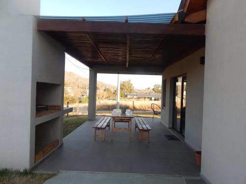 eine Terrasse mit einem Tisch und 2 Stühlen darauf in der Unterkunft La Calma in Villa General Belgrano