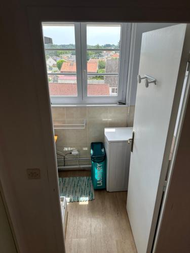 un piccolo bagno con finestra e frigorifero bianco di Appartement Stella-Plage Proche Touquet-Paris-Plage a Stella-Plage