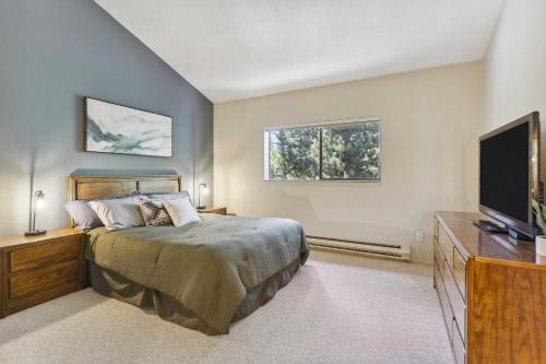 a bedroom with a bed and a flat screen tv at Cozy Winter Park Condo Bike, Ski, and Hike! in Winter Park