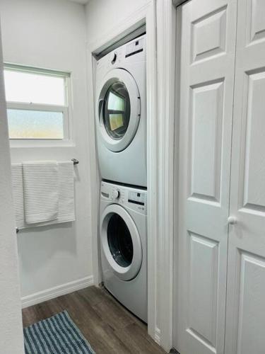 a washer and dryer in a room with a door at Roy's guest house in Orlando